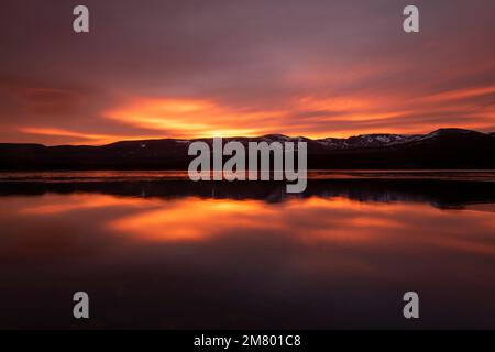 Sonnenaufgang über Loch Morlich und den Cairngorm Mountains, Cairngorms National Park in der Nähe von Aviemore, Badenoch und Strathspey, Schottland, Großbritannien Stockfoto