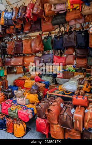 Florenz, Italien - 03. Juni 2022: Farbenfrohe Lederwaren, Taschen und Rucksäcke werden in einem Straßenladen auf dem Zentralmarkt Mercato Centrale ausgestellt Stockfoto