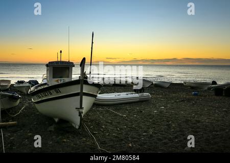 Las Negras, Almeria, Spanien - 17. November 2022: Fischerboote unter Sturmwetter am Strand in Spanien Stockfoto