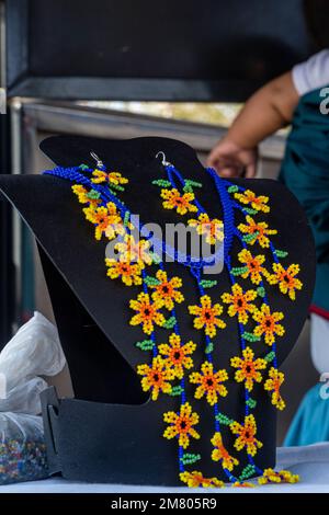 Mexikanische Huichol Perlenhalsketten mit Chaquira-Blüten auf dem Markt handgemachtes Kunsthandwerk sehr mühsam Stockfoto