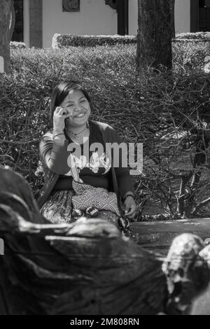 Eine Frau, die am Telefon spricht, in einem traditionellen Kostüm der wixarika huichol-Kultur Stockfoto