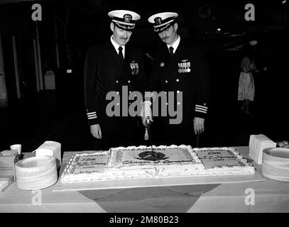 CDR Richard G. Simms, Right, ehemaliger Kommandeur der taktischen Elektronischen Kriegsführung 131. (VAQ-131) und sein Nachfolger, CDR James C. Kennedy, Left, Schnitt den Kuchen am Ende der Zeremonie zum Kommandowechsel. Die Zeremonie fand in Hangar Acht statt. Basis: Marine Air Station Whidbey Island Staat: Washington (WA) Land: Vereinigte Staaten von Amerika (USA) Stockfoto