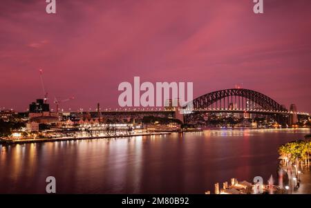 Dramatischer violetter und rosafarbener Himmel bei Sonnenaufgang über der Sydney Harbour Bridge und dem Circular Quay in Sydney Stockfoto