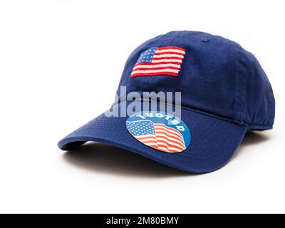 Ich habe für einen Aufkleber auf einem patriotischen blauen Baseballhut gestimmt, mit amerikanischer Flagge auf weißem Hintergrund. Stockfoto