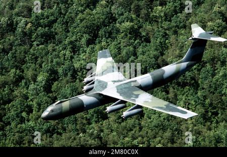 Eine Luft-zu-Luft-Ansicht von links von oben eines getarnten C-141B Starlifter-Flugzeugs. Land: Unbekannt Stockfoto