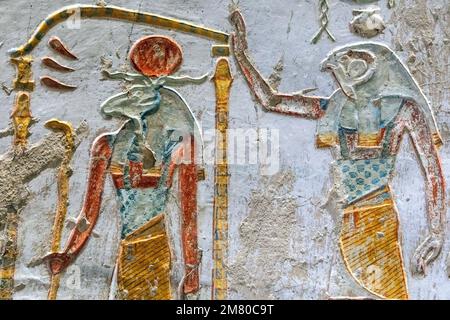 DER GOTT HORUS MIT DEM KOPF EINES FALKEN UND ANUBIS (BESTATTUNGSGOTT MIT DEM KOPF EINES WILDEN HUNDES), GRAB DES PHARAOS MERENPTAH, TAL DER KÖNIGE, LUXOR, ÄGYPTEN, AFRIKA Stockfoto