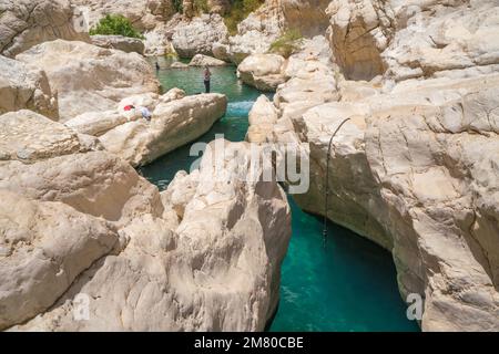 Wadi Bani Khalid, Oman - 04.05.2018 Uhr: Kleine, schmale, weiße Steinschlucht mit türkisfarbenem Wasser in Wadi Bani Khalid, Oman. Wunderschöner natürlicher Swimmingpool Stockfoto