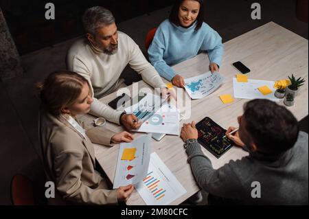 Unterschiedliche Kollegen schätzen die Präsentation und die emotionale Diskussion im modernen Büro Stockfoto