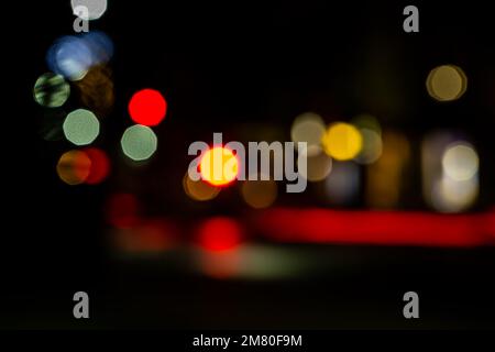 Unscharfe Spuren von Lichtern und Flecken. Hintergrund voller unfokussierter farbiger Lichtquellen. Stockfoto