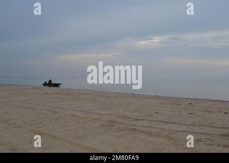 Beschaulicher Nebelmorgen an der Küste von Corpus Christi, Texas – Eine friedliche Hafenlandschaft mit einem einsamen Boot, das durch den Nebel gleitet Stockfoto