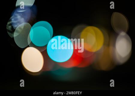 Unscharfe Spuren von Lichtern und Flecken. Hintergrund voller unfokussierter farbiger Lichtquellen. Stockfoto