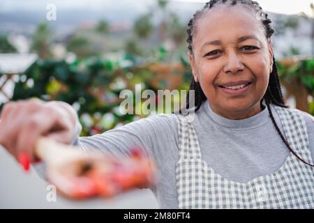 Seniorin bietet einen köstlichen Gemüse-Rührbraten für gesunde Ernährung - gesundes Essen und Gesundheitskonzept Stockfoto