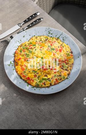 Omelette gefüllt mit Tomaten, rote Paprika und Brokkoli auf hellem Holztisch. Gesunde Ernährung Essen zum Frühstück. Lecker morgen essen. Stockfoto