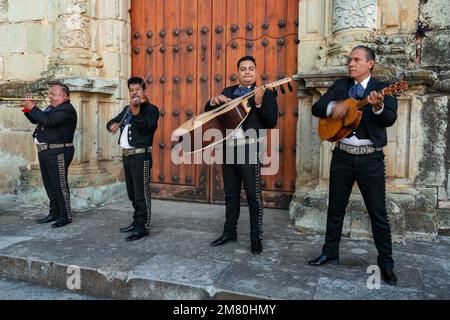 Eine Mariachi-Band in Charro-Kostümen tritt auf den Stufen der Kirche Santo Domingo im historischen Oaxaca, Mexiko, auf. Stockfoto