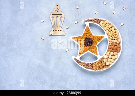Ramadan-Karäem mit getrockneten Früchten und Nüssen in Form eines Halbmonds. Iftar-Essenskonzept. Draufsicht, Kopierbereich Stockfoto