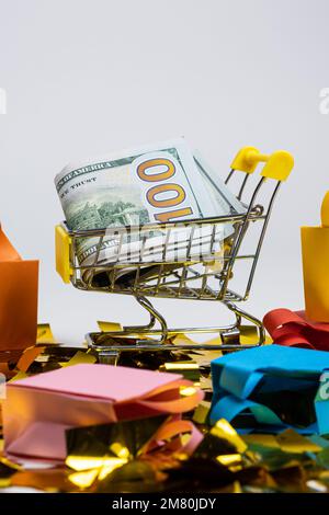 Einkaufstaschen und ein Wagen mit Geld auf weißem Hintergrund. Das Konzept des Verkaufs. Stockfoto