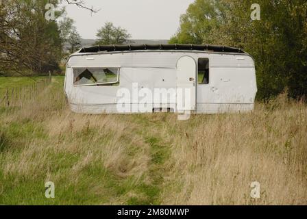 Geparkter verdorbener Wohnwagen auf einer Weide Stockfoto