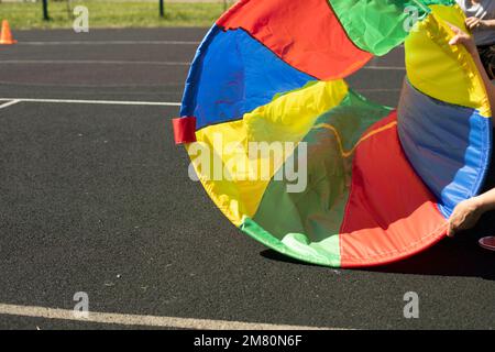 Sportausrüstung im Sommer. Farbiger Stoff. Ring für Relais. Details zum Spaß auf dem Spielplatz. Stockfoto