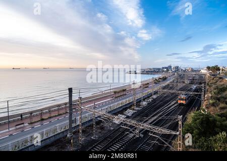 Tarragona - Katalonien, SPANIEN - 29. Dezember 2022: Allgemeiner Blick auf die Stadtküste bis zum Mittelmeer, mit RENFE-Bahnschienen parallel zur Küste, zum Stadtstrand und zum Hafen. Stockfoto