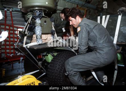 Air Force-Personal hat ein dreirädriges Geländefahrzeug im Frachtraum eines C-130-Herkules-Flugzeugs für den Transport nach Travis Field, Georgia, festgebunden, während der Einsatzbereitschaft des taktischen Luftwaffenflügels 314. Purple Penny. Betreff Betrieb/Serie: PURPLE PENNY Base: Little Rock Air Force Base Bundesstaat: Arkansas (AR) Land: Vereinigte Staaten von Amerika (USA) Stockfoto