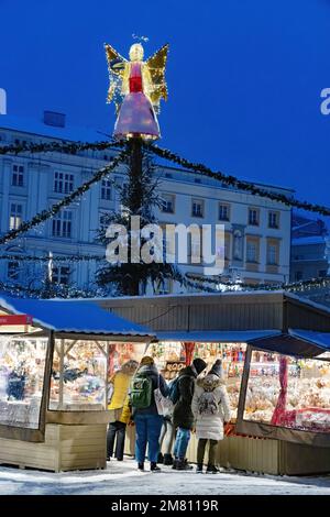 Krakauer Weihnachtsmarkt - Leute, die nachts in einem Marktstand auf dem Krakauer Hauptmarktplatz, der Krakauer Altstadt, Krakau Polen Europa einkaufen Stockfoto