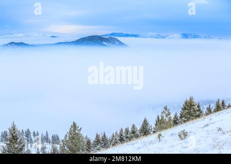 Dichter Winternebel im helena-Tal und weit entfernter schlafender Riesenberg mit Blick vom helena-Berg in helena, montana Stockfoto