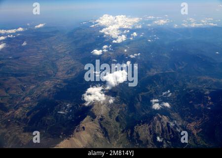 Blick aus dem Flugzeugfenster auf die französischen Pyrenäen mit Altocumulus Stratiformis Wolken. Stockfoto
