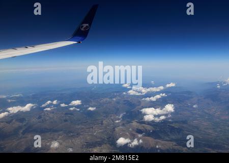 Blick vom Flugzeugfenster auf das TS-Airlines-Logo und den Flügel Stockfoto