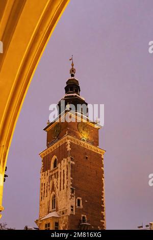 Der nächtliche Rathausturm von Krakau wird beleuchtet, durch einen Bogen in der Tuchhalle, den Hauptmarktplatz, die Krakauer Altstadt, Krakau Polen gesehen Stockfoto