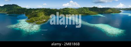 Ausgedehnte Korallenriffe säumen Regenwaldinseln auf den Salomonen. Dieses wunderschöne Land ist die Heimat einer spektakulären marinen Artenvielfalt. Stockfoto