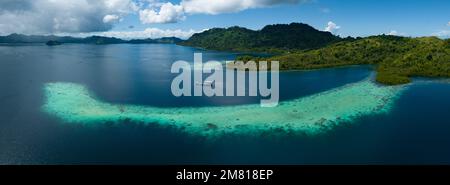 Ausgedehnte Korallenriffe säumen Regenwaldinseln auf den Salomonen. Dieses wunderschöne Land ist die Heimat einer spektakulären marinen Artenvielfalt. Stockfoto