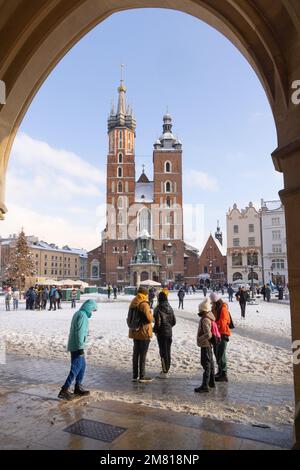 Krakau Polen; Marienkirche, eine gotische Kirche auf dem Krakauer Marktplatz im Winterschnee, von der Tuchhalle aus gesehen, Krakauer Altstadt, Polen Europa Stockfoto
