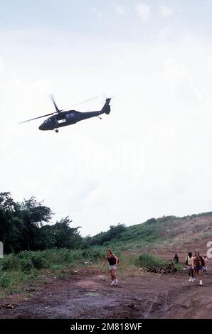 Ein US Army UH-60 Black Hawk Helikopter überfährt Studenten vom St. George's University Medical College auf dem Weg zum Point Salines Flugplatz. Sie werden von der Insel evakuiert während der multifunktionalen, multinationalen Operation, DIE DRINGEND WÜTET. Betreff Betrieb/Serie: URGENT FURY Country: Grenada (GRD) Stockfoto