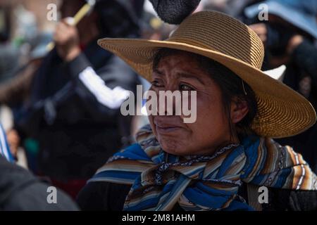 Juliaca, Peru. 11. Januar 2023. Eine Frau weint, während Verwandte und Dorfbewohner sich von Dutzenden Toten verabschieden, die bei schweren Zusammenstößen mit der Polizei während einer Demonstration starben. Die Proteste waren gegen die Regierung des Interimspräsidenten Boluarte gerichtet. Die Demonstranten forderten den Rücktritt des Staatsoberhaupts. Boluarte hatte die Macht übernommen, als das Parlament Präsident Castillo aus dem Amt enthielt. Kredit: Denis Mayhua/dpa/Alamy Live News Stockfoto