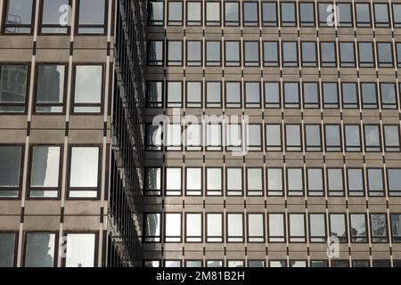 Architektonische Details eines modernen Gebäudes mit reflektierenden Glasfenstern. Stockfoto