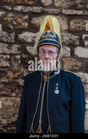 Porträt eines älteren Herrn mit grauem Bart, trägt eine Militäruniform mit Helm und schaut direkt in die Kamera. Stockfoto