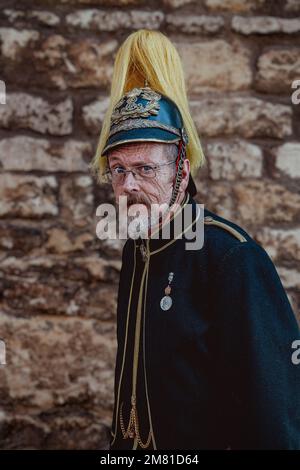 Porträt eines älteren Herrn mit grauem Bart, trägt eine Militäruniform mit Helm und schaut direkt in die Kamera. Stockfoto