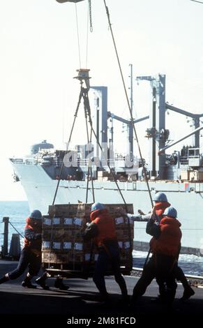 Besatzungsmitglieder an Bord des Schlachtschiff USS NEW JERSEY (BB 62) führen während der Wiederauffüllung mit dem Kampfschiff USS SYLVANIA (AFS 2) eine Palette auf das Deck des Schiffs. Das NEW JERSEY operiert vor der Küste von Beirut, Libanon. Land: Mittelmeer (MED) Stockfoto