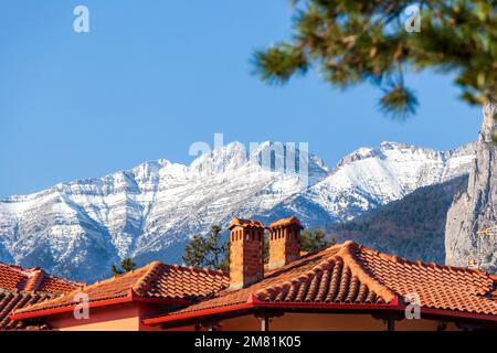 Blick auf die schneebedeckte Landschaft über dem berühmten Olymp, der über den Dächern der Stadt Litochoro in der Region Mazedonien, Nordgriechenland, Europa zu sehen ist. Stockfoto