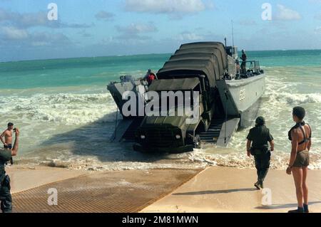 Marines und Matrosen entladen während der Operation KERNAL BLITZ einen 2 1/2-Tonnen-Lkw von einem mechanisierten Landungsfahrzeug (LCM Mark 8) auf den Strand. Betreff Betrieb/Serie: KERNAL BLITZ Base: Bellows Beach, Oahu Bundesstaat: Hawaii (HI) Land: Vereinigte Staaten von Amerika (USA) Stockfoto