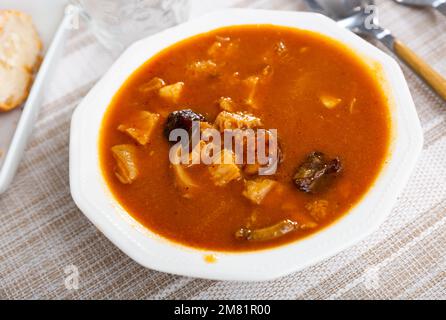 Callos a la Madrilena serviert auf einem Holztisch Stockfoto