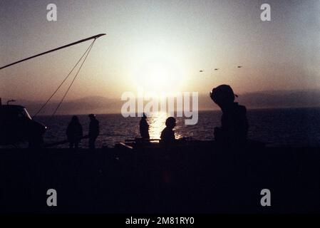 Besatzungsmitglieder an Bord des Amphibienschiffs USS GUAM (LPH 9) werden während Operationen vor der libanesischen Küste Beirut in der frühen Morgensonne abgeschirmt. Basis: USS Guam (LPH 9) Land: Mittelmeer (MED) Stockfoto