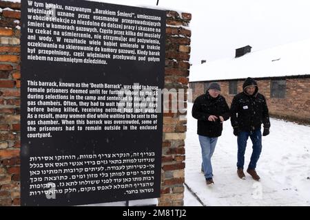 Auschwitz Touristen und Schild; Männer aus der Todesbaracke, Auschwitz Birkenau Nazi Konzentrationslager Museum, im Winter Schnee, Auschwitz, Polen Stockfoto