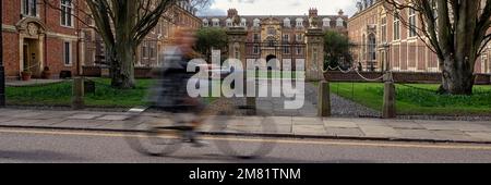 CAMBRIDGE, Großbritannien - 11. MÄRZ 2020: Panoramablick auf die Fassade des St. Catharine's College mit Radfahrer in Bewegung Stockfoto