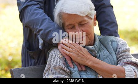 Nahaufnahme einer Seniorin, die den Kopf auf der Hand des Mannes auf der Schulter im Freien ruht. Hochwertiges Foto Stockfoto