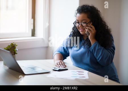 Millennials-Unternehmerin junge, dicke Frau, die von zu Hause aus arbeitet Stockfoto