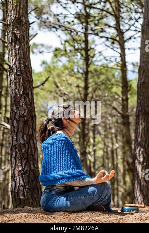 Seitenansicht einer Frau, die sich im Wald die Hände zusammenschlägt. Stockfoto