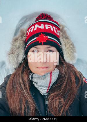 Nahaufnahme einer Frau in warmer Winterkleidung, die im Schnee lag. Stockfoto