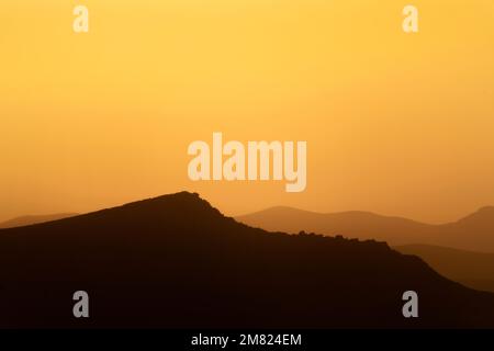 Sonnenaufgang über der Silhouette der Berge im Januar 2022 Stockfoto