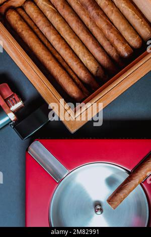 Blick auf Zigarren im Humidor und Aschenbecher. Flach verlegt Stockfoto